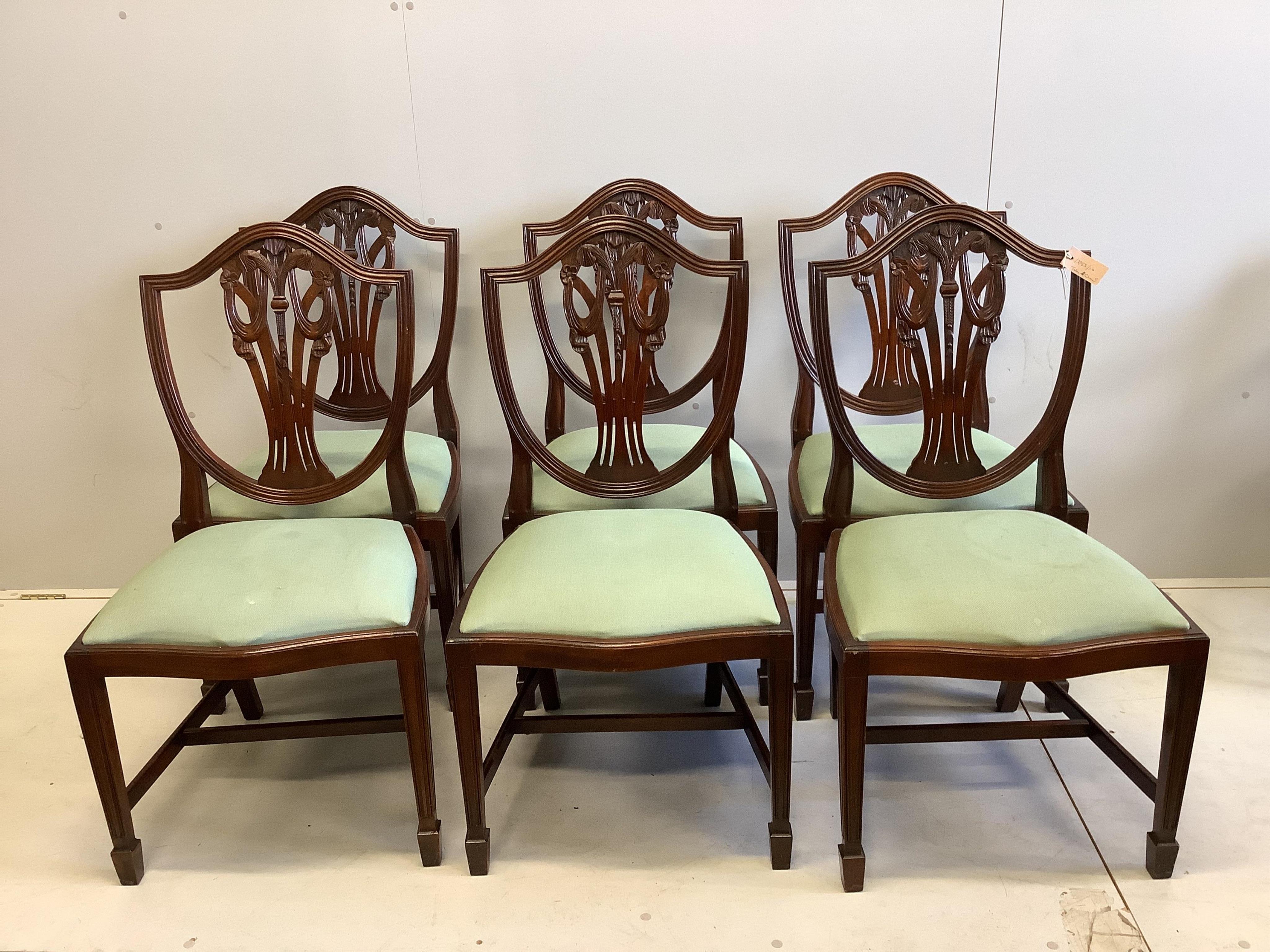 A Georgian style banded mahogany extending dining table, raised on twin turned supports and quadruple reeded splayed legs with brass castors (two additional leaves), 260cm extended, width 110cm, height 74cm, together wit